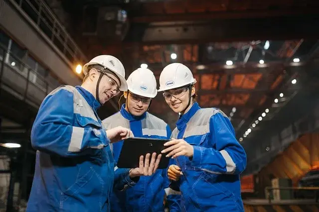 Tablet üzerinden bilgileri inceleyen endüstriyel çalışma ekibi